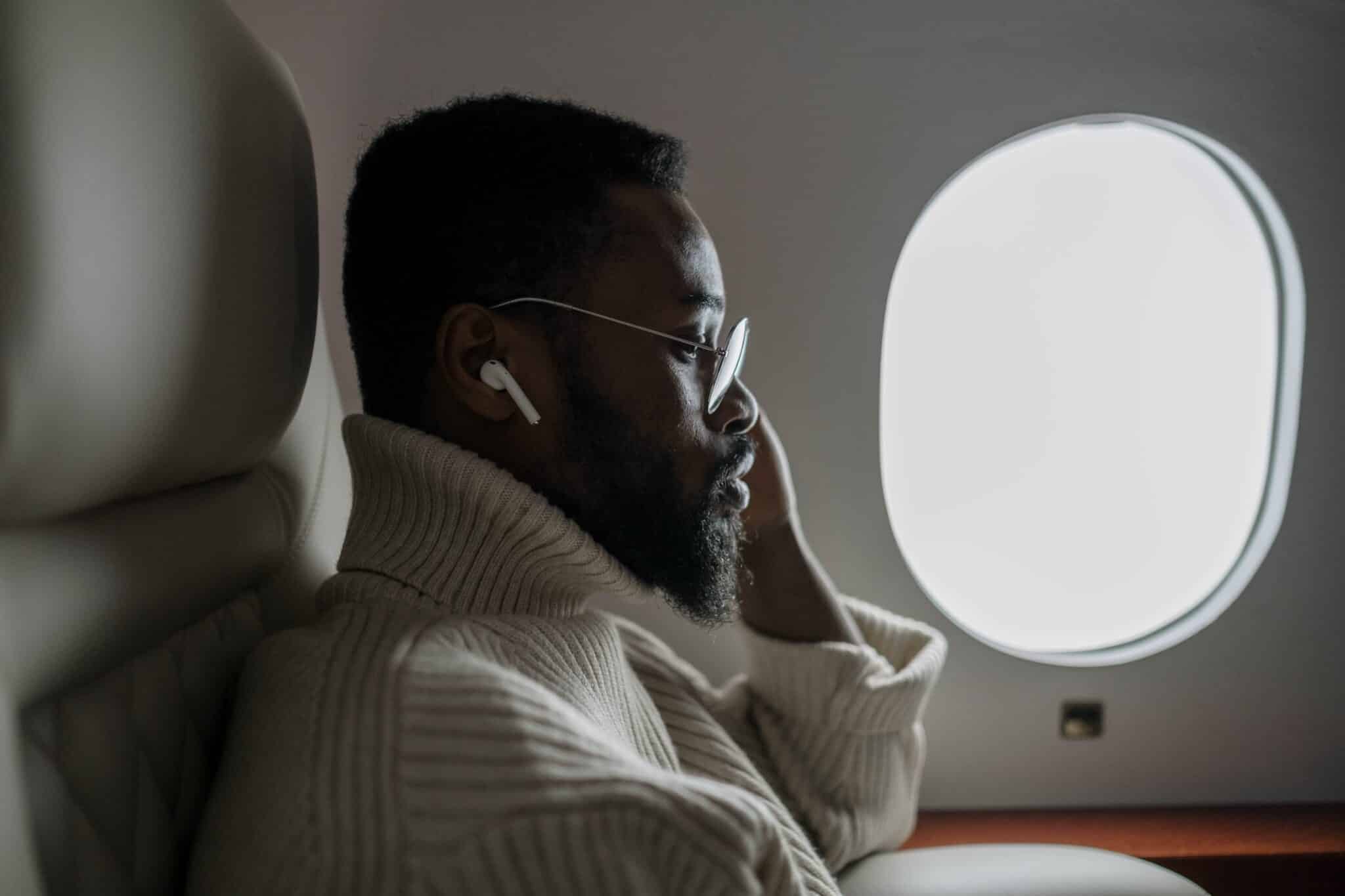 Man sitting in the window seat while flying.