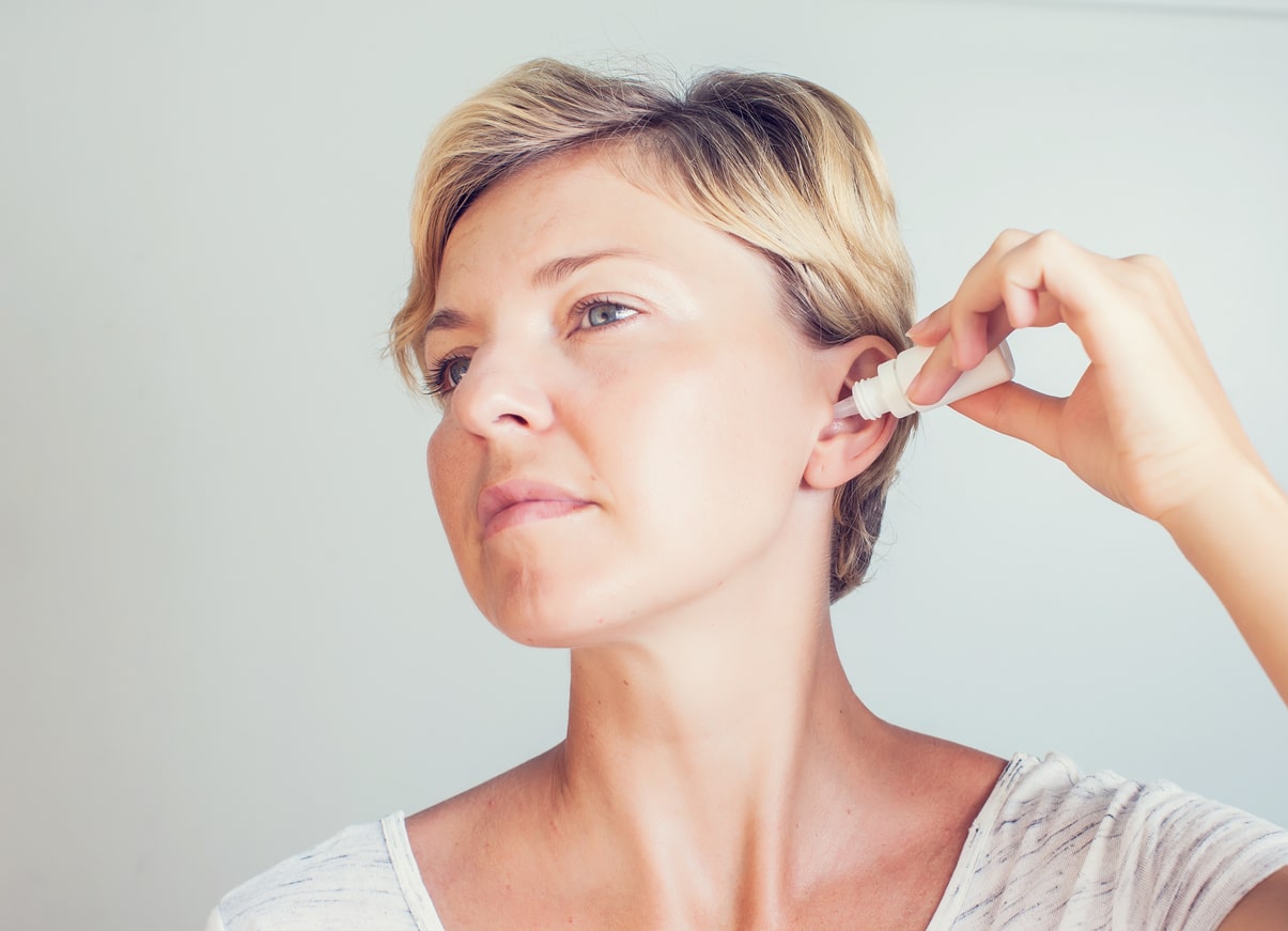 Woman using ear drops.