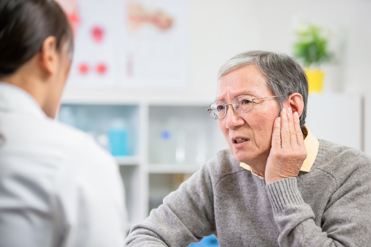 Man explaining ear pain to his ENT specialist