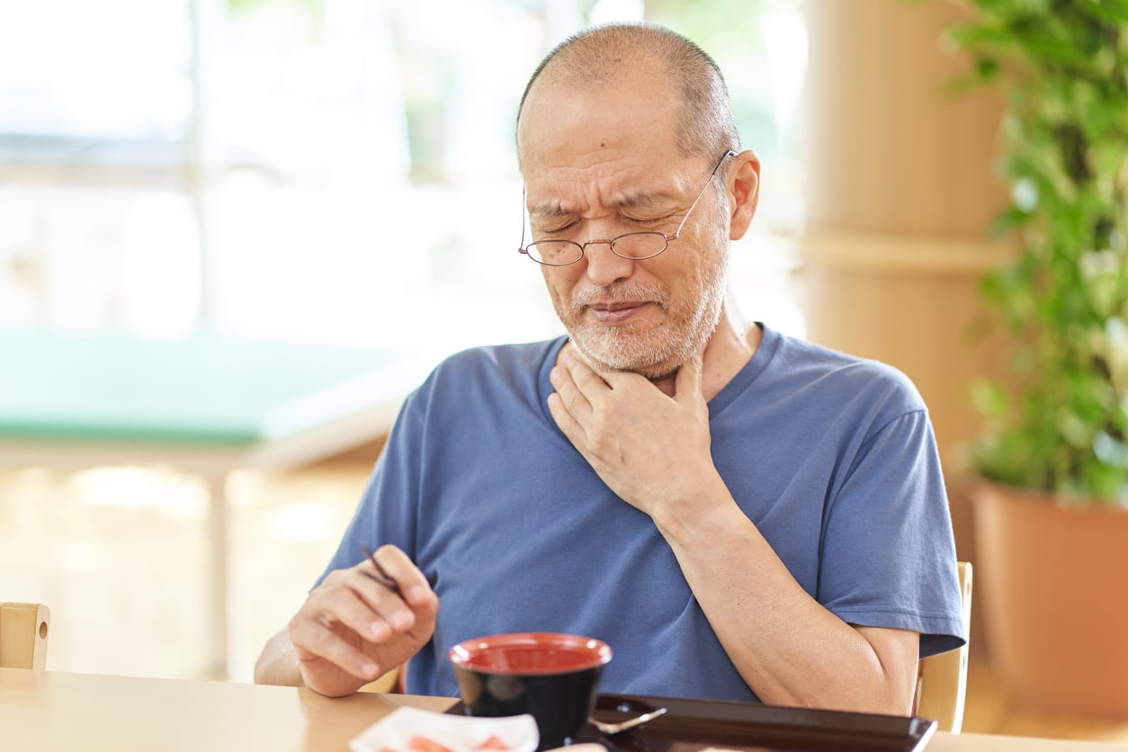 Man having trouble swallowing his coffee