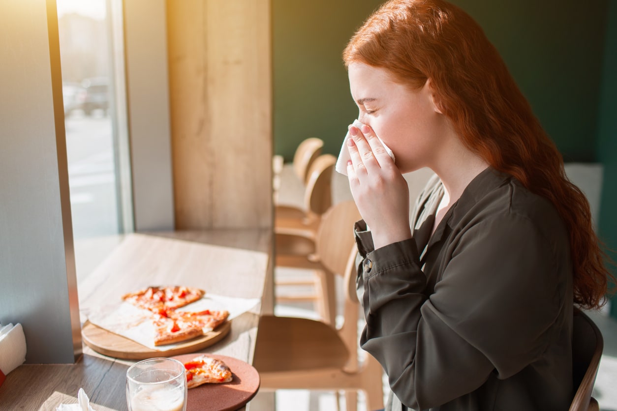 Woman blowing nose during dinner