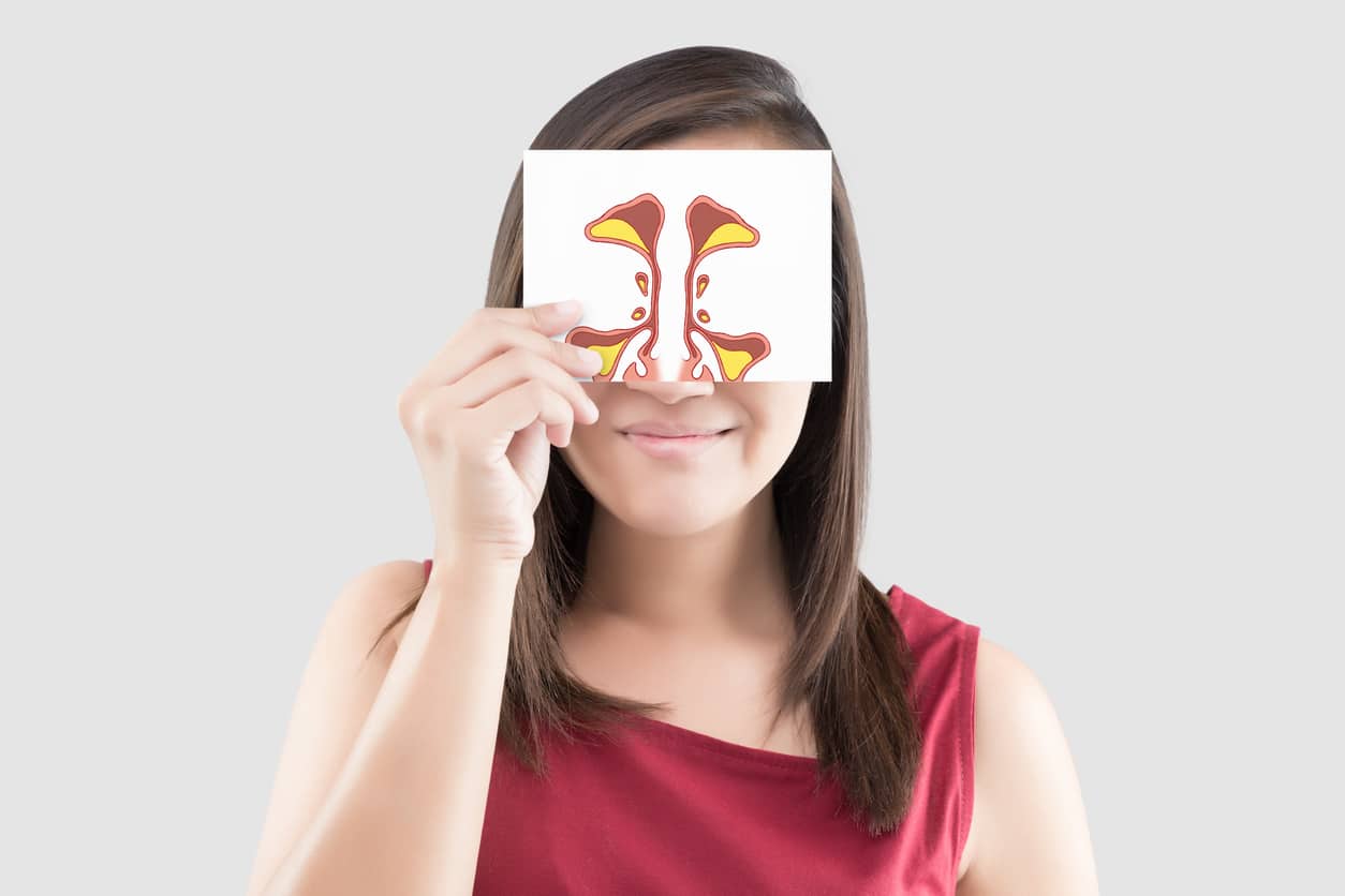 Woman holding up a card with a sinus illustration on it