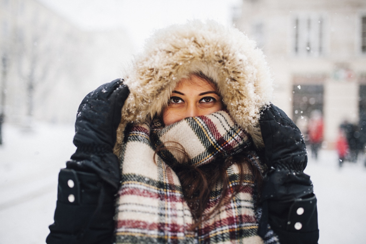 Woman all bundled up standing in the snow