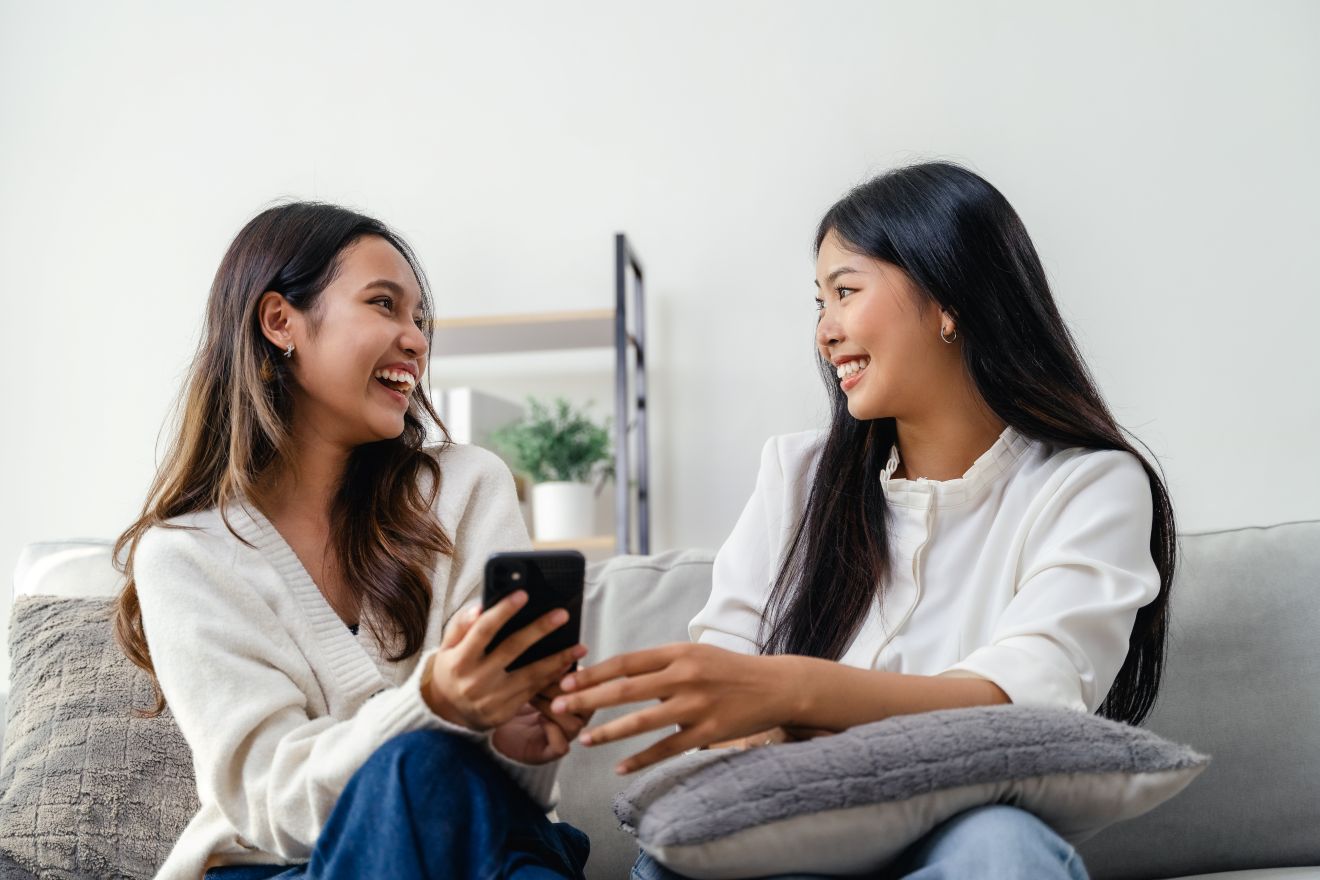 voice-disorders-evaluation Two women sitting together talking and laughing