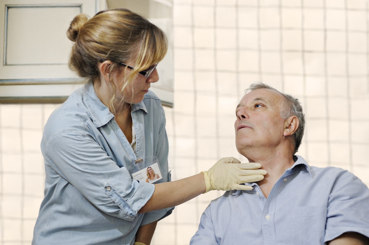 Healthcare worker checking man's throat