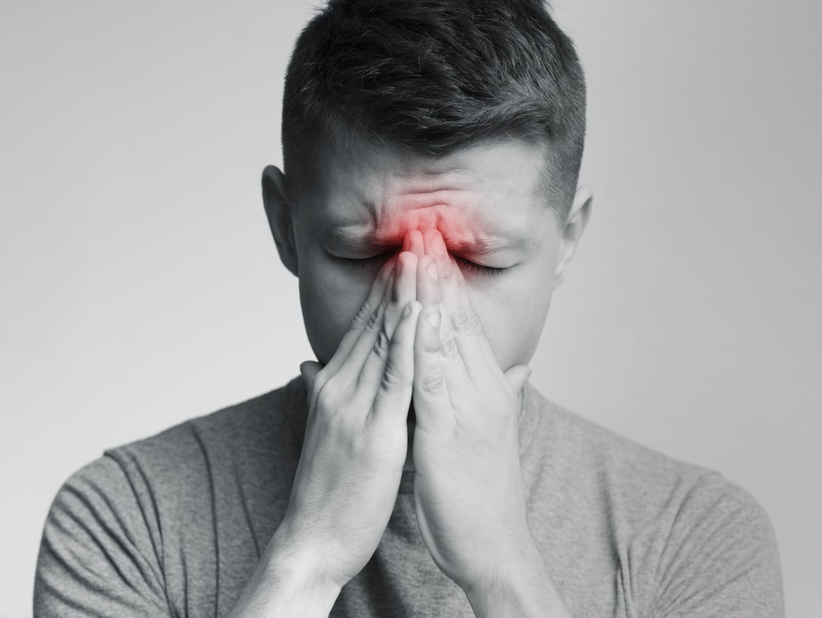Man holding his nose because sinus pain